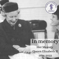 Picture of Queen Elizabeth II smiling while receiving a hand reflexology treatment back in the 80