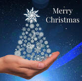Picture of a Christmas tree made of snowflakes and held in the open palm of a hand. Message reads happy Christmas